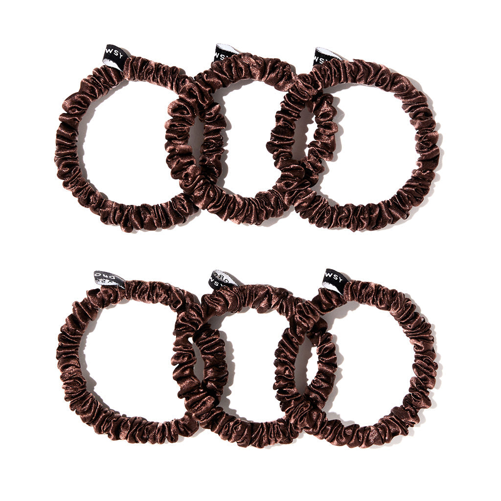 The drowsysleepco Skinny Scrunchie Set - Cocoa Glow features six brown velvet scrunchies with black tags, arranged in two rows on a white background—ideal for gentle hair support compared to skinny silk alternatives.