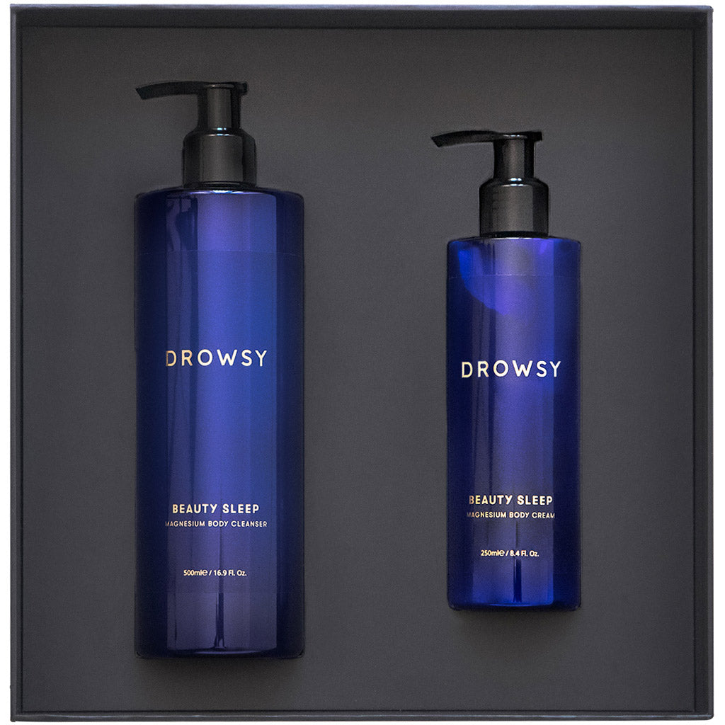 The Beauty Sleep Ritual by us.drowsysleepco includes two blue bottles in a black box: a large Magnesium Body Cleanser and a small Magnesium Body Cream, both for magnesium-infused body care to enhance your beauty sleep.
