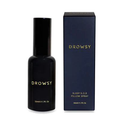 A black bottle labeled Drowsy stands next to a matching dark blue box labeled Drowsy Sleep S.O.S Pillow Spray, 50 ml / 1.7 fl. oz on a white background.