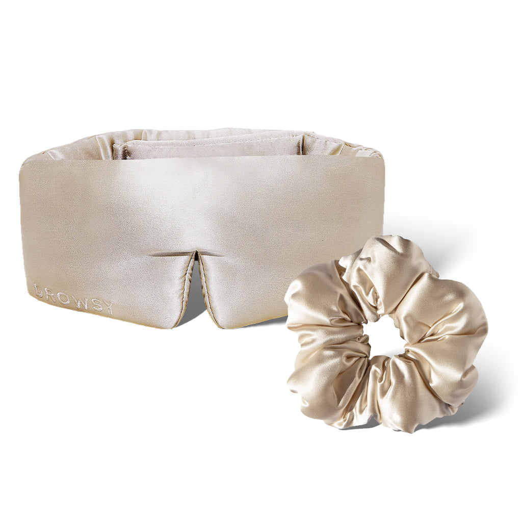 The drowsysleepco Silky skin & hair bundle in Dusty Gold features a beige satin padded headband with “DROWSY” embroidery and a matching scrunchie, both shown on a white background.