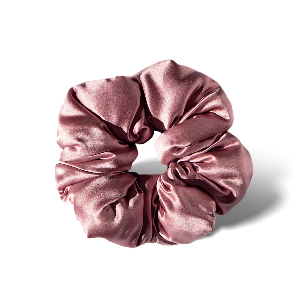 The Damask Rose - Padded Scrunchie by us.drowsysleepco is a shiny, light pink oversized silk scrunchie displayed in a circular shape on a white background with a soft shadow to the right.