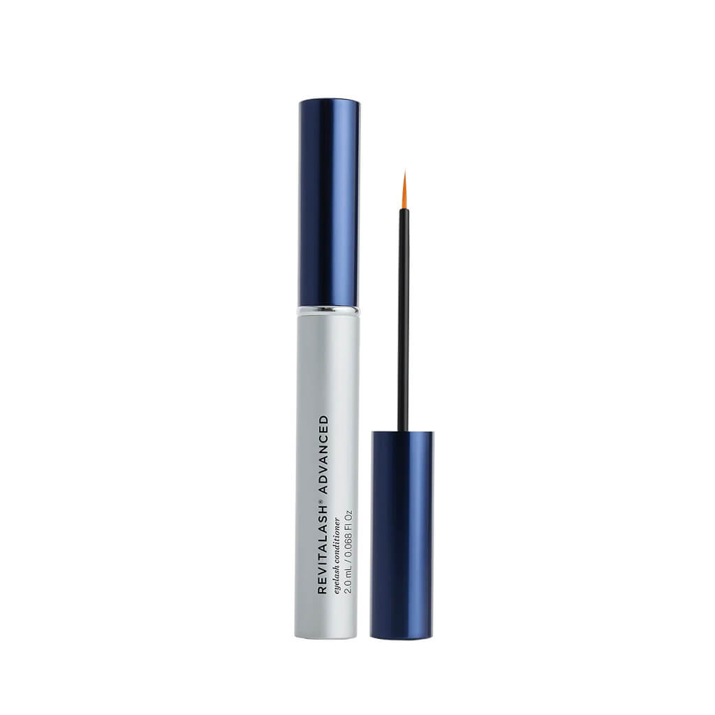 A silver tube with a blue cap labeled RevitaLash® Cosmetics x Drowsy® Dream Lashes Kit by Drowsy stands beside its open applicator, featuring a fine brush tip and matching blue handle, all set against a white background.
