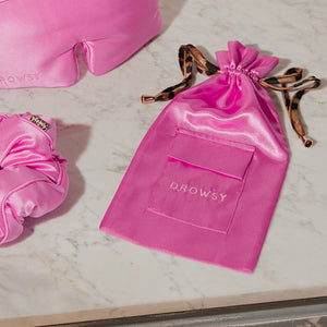 A Hotel Paradiso Carry Pouch from us.drowsysleepco sits on a marble surface next to a matching silk eye mask and scrunchie, forming an elegant and cozy travel accessory set.