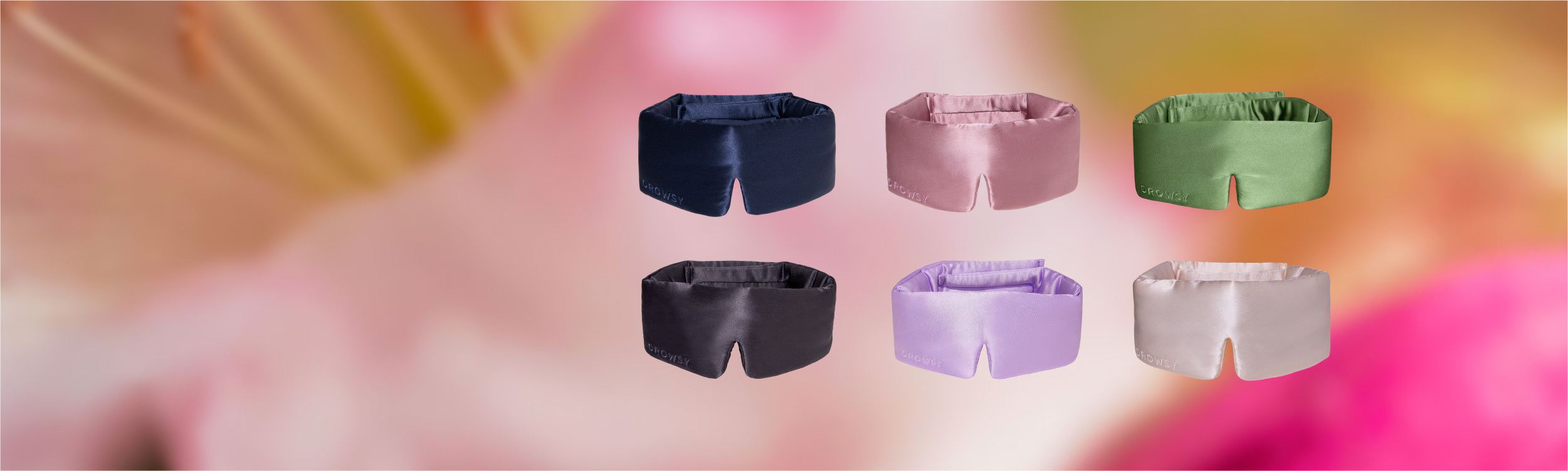 Six pairs of shorts in navy, pink, green, black, lavender, and beige, displayed in two rows against a blurred floral background in shades of pink and yellow.