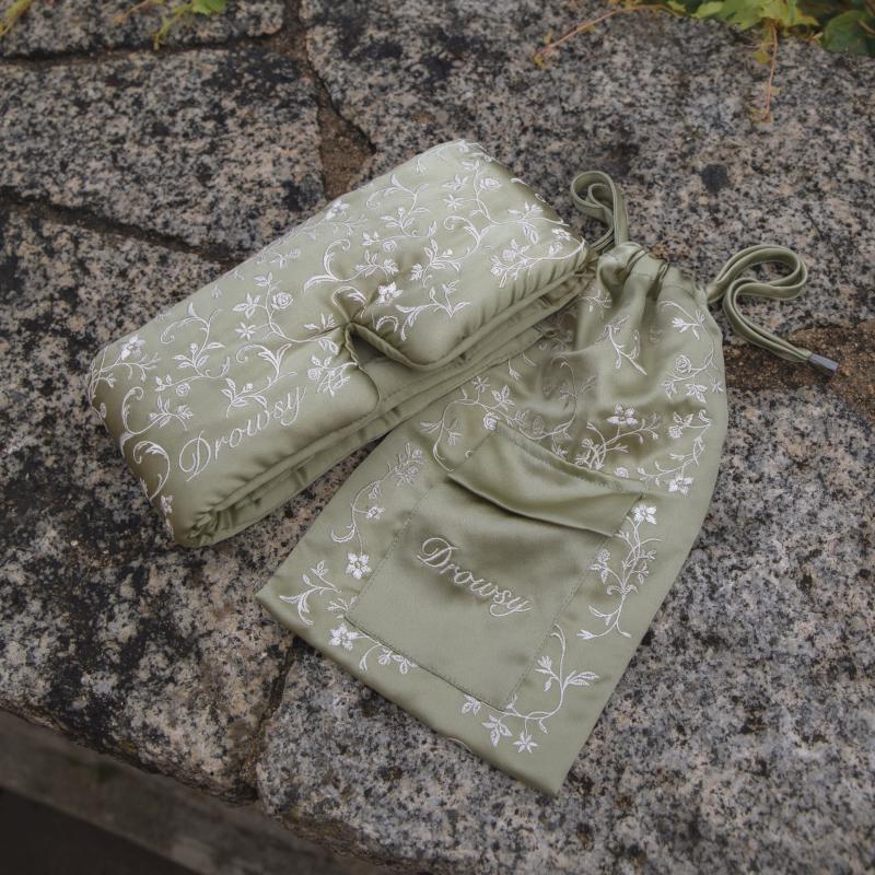Sage green Pride & Prejudice - Complete collection original mulberry silk sleep mask and matching drawstring pouch, both featuring a white floral pattern and embroidered logo.