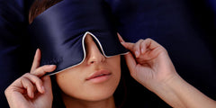 Model sleeping with blue Drowsy silk sleep mask covering eyes
