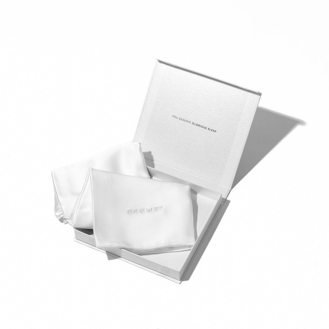 White pillowcase box opening with white silk pillowcase inside