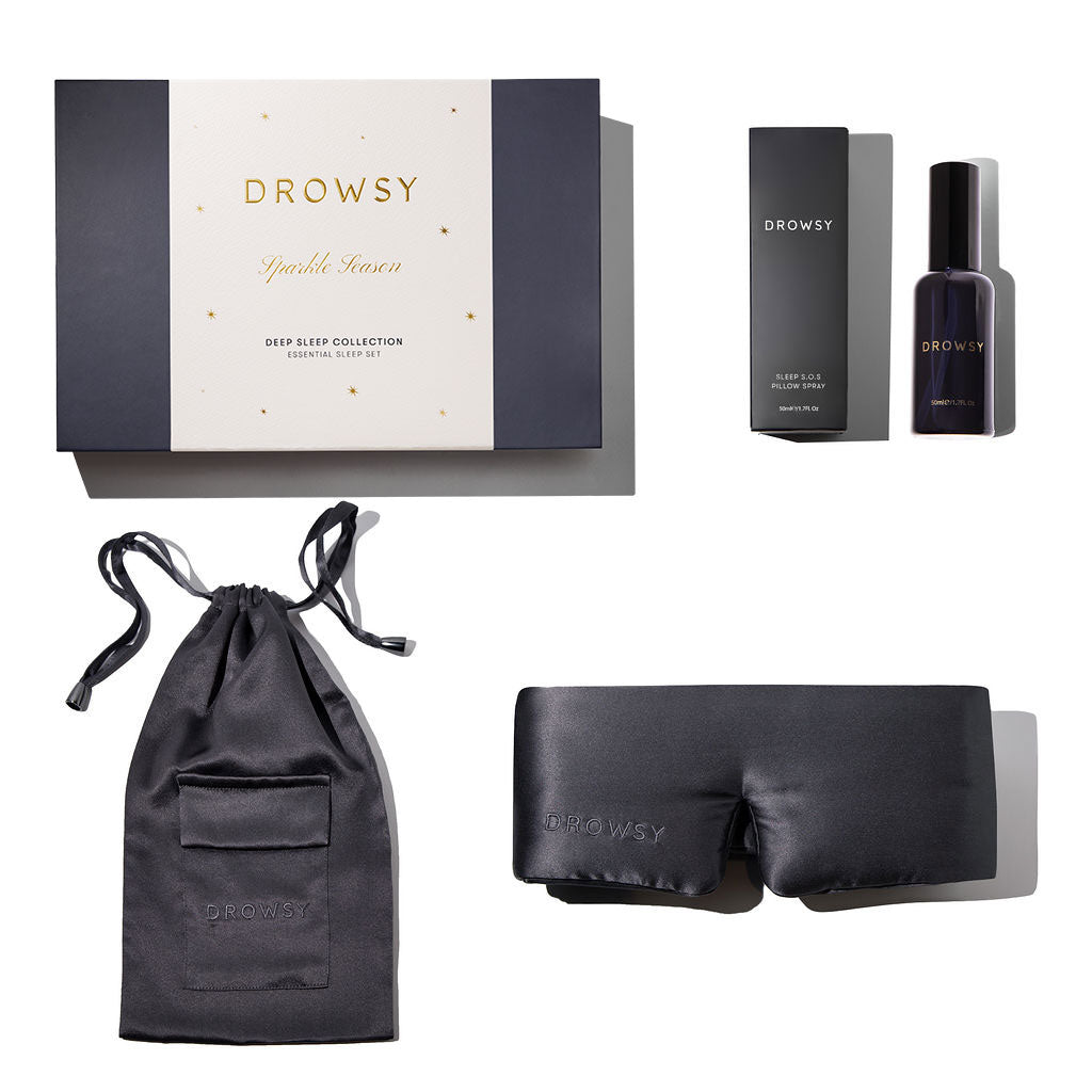 The us.drowsysleepco Moonlight Shadow - Deep Sleep Collection includes a luxury silk sleep mask, matching drawstring pouch, box, and deep sleep pillow spray with packaging—an ideal set of sleep essentials displayed on a white background.
