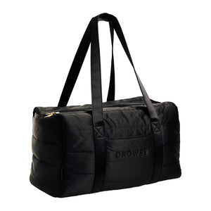 The Drowsy Silk Weekender - Black Jade is a stylish black quilted bag with two long handles, a zippered top, and Drowsy embroidered on the side—ideal for carrying your travel essentials.