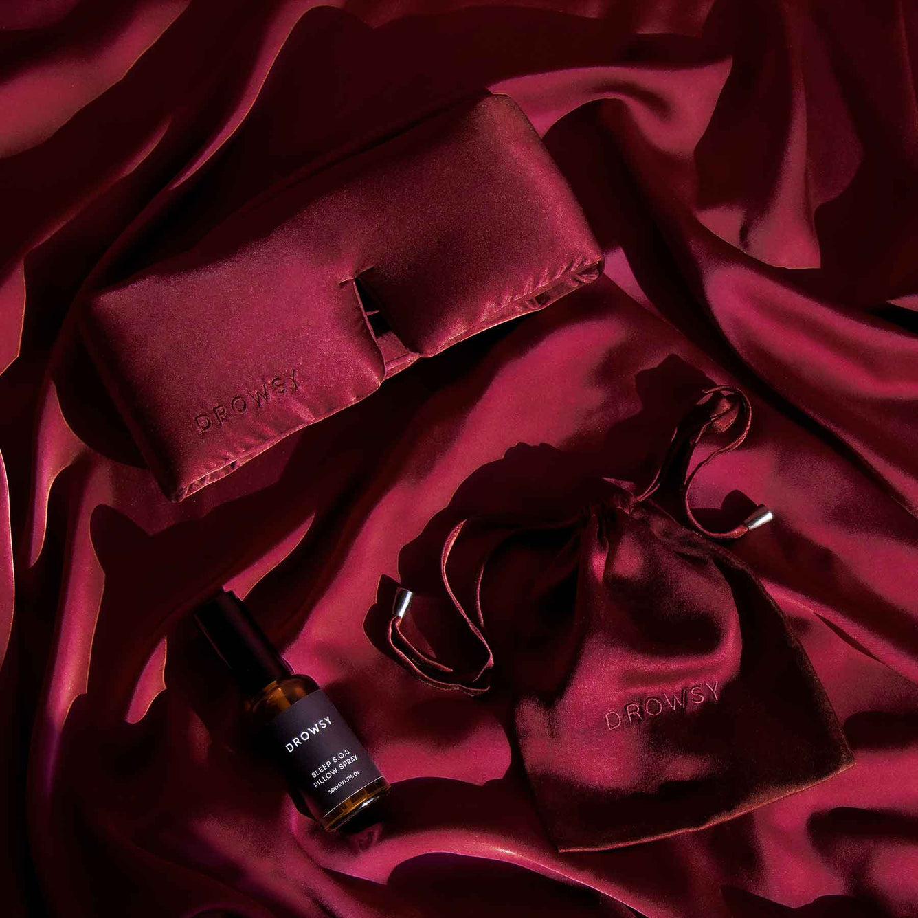 Drowsy La Vie En Rouge sleep mask and pillow spray on Red silk background