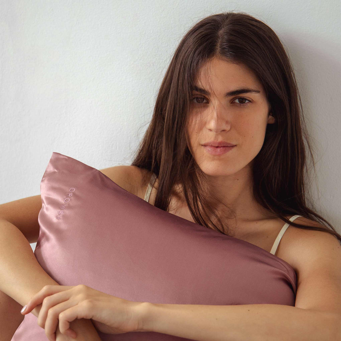 Model hugging pink Drowsy silk pillowcase