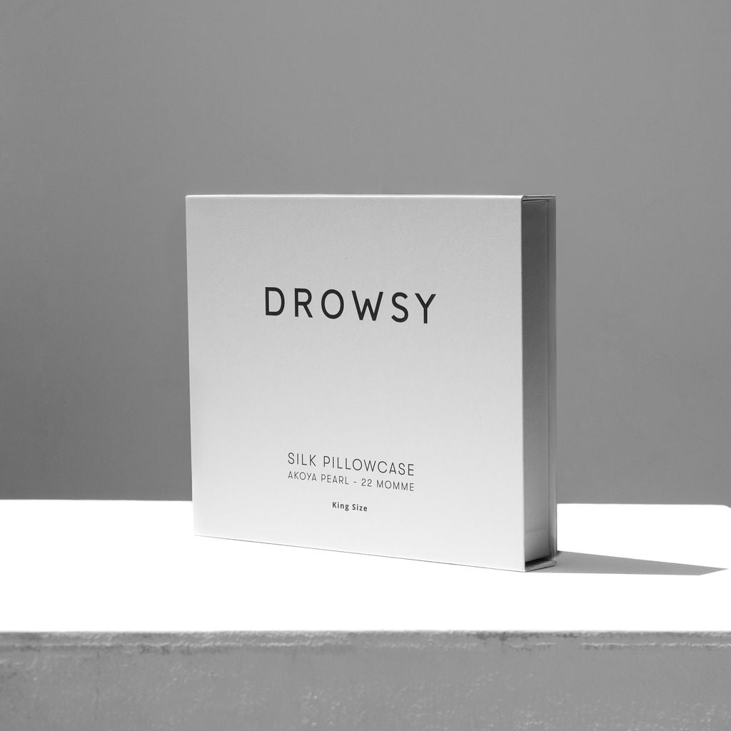 White Drowsy silk pillowcase box on a white stand with grey background