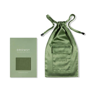 A Pistachio Green Silk Carry Pouch by us.drowsysleepco is shown with a matching drawstring pouch featuring the Drowsy logo. The box label reads Drowsy Silk Mask + Caddy Pouch, Pistachio Green.