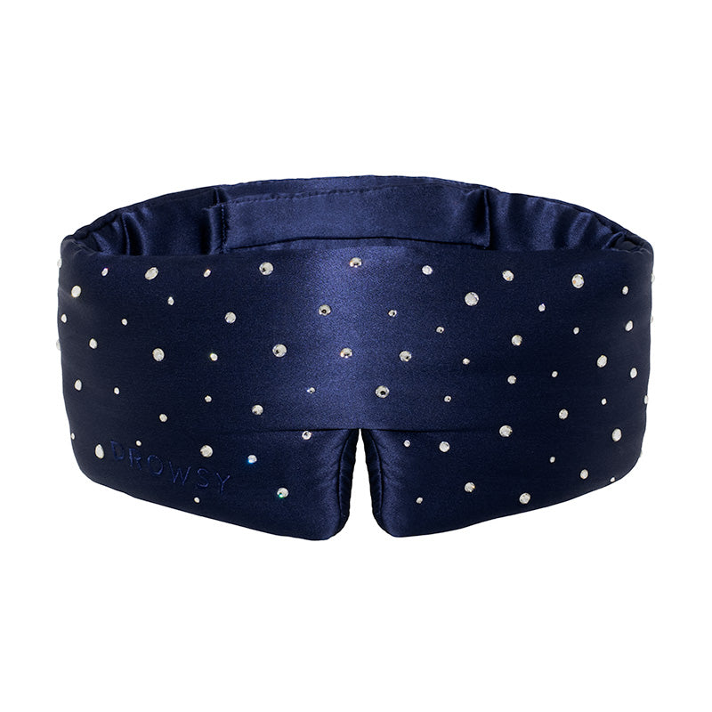 The Silk Sleep Eye Mask Crystals by Swarovski® from drowsysleepco is a navy silk eye mask with sparkling Swarovski crystals, a wide padded design for 100% blackout, and Drowsy subtly embossed on the left side.