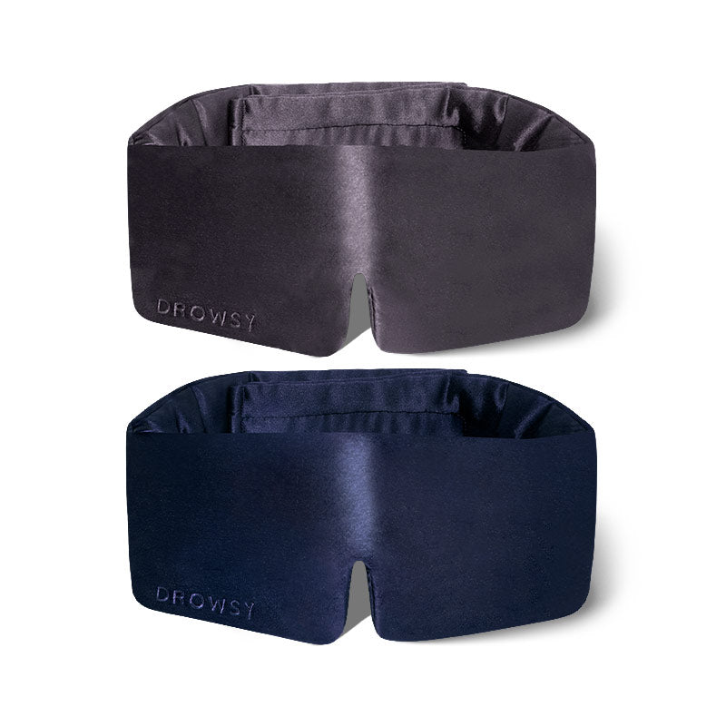 The drowsysleepco 2-Pack Sleep Masks in Midnight Blue and Moonlight Shadow feature wide, padded silk designs with "DROWSY" embroidery on the lower left, shown against a white background.