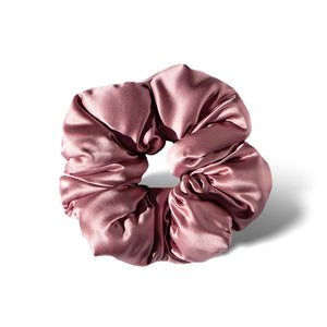 The Damask Rose - Padded Scrunchie by us.drowsysleepco is a shiny, light pink oversized silk scrunchie displayed in a circular shape on a white background with a soft shadow to the right.