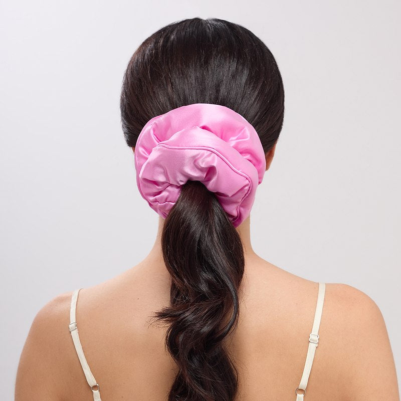 A person with long dark hair in a low ponytail, secured with the us.drowsysleepco Hotel Paradiso - Heatwave Padded Scrunchie for added volume, is seen from behind wearing a light spaghetti strap top against a plain background.